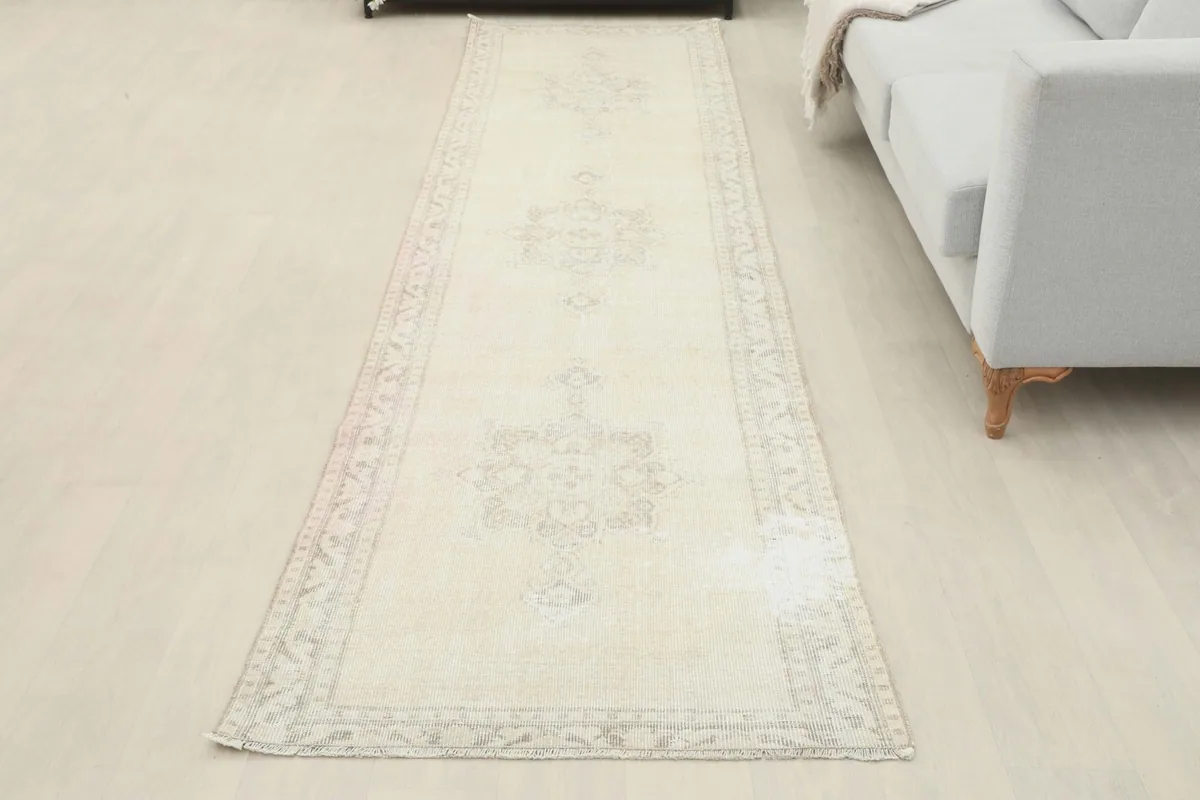 Overhead view of the cream runner rug in a room setting, beside a sofa