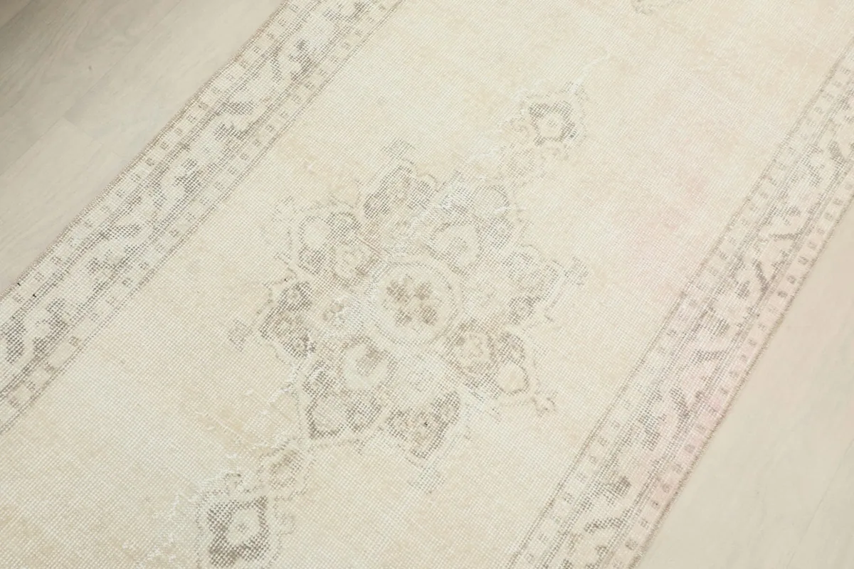 Close-up of a central geometric medallion motif on the cream vintage runner