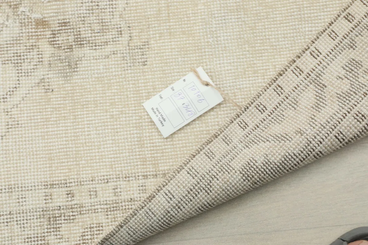 Rug corner with a product tag, displaying the texture of the wool and cotton foundation