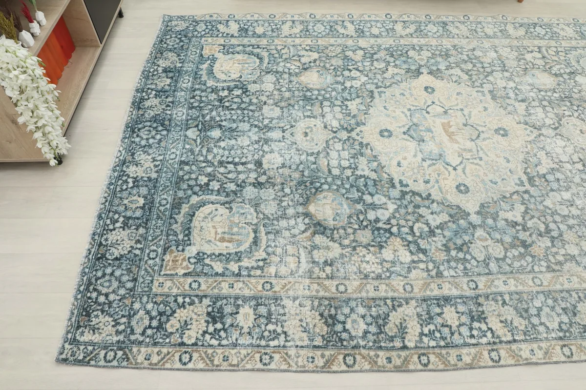 Angled view showcasing the side and corner of the blue vintage rug with its intricate patterns