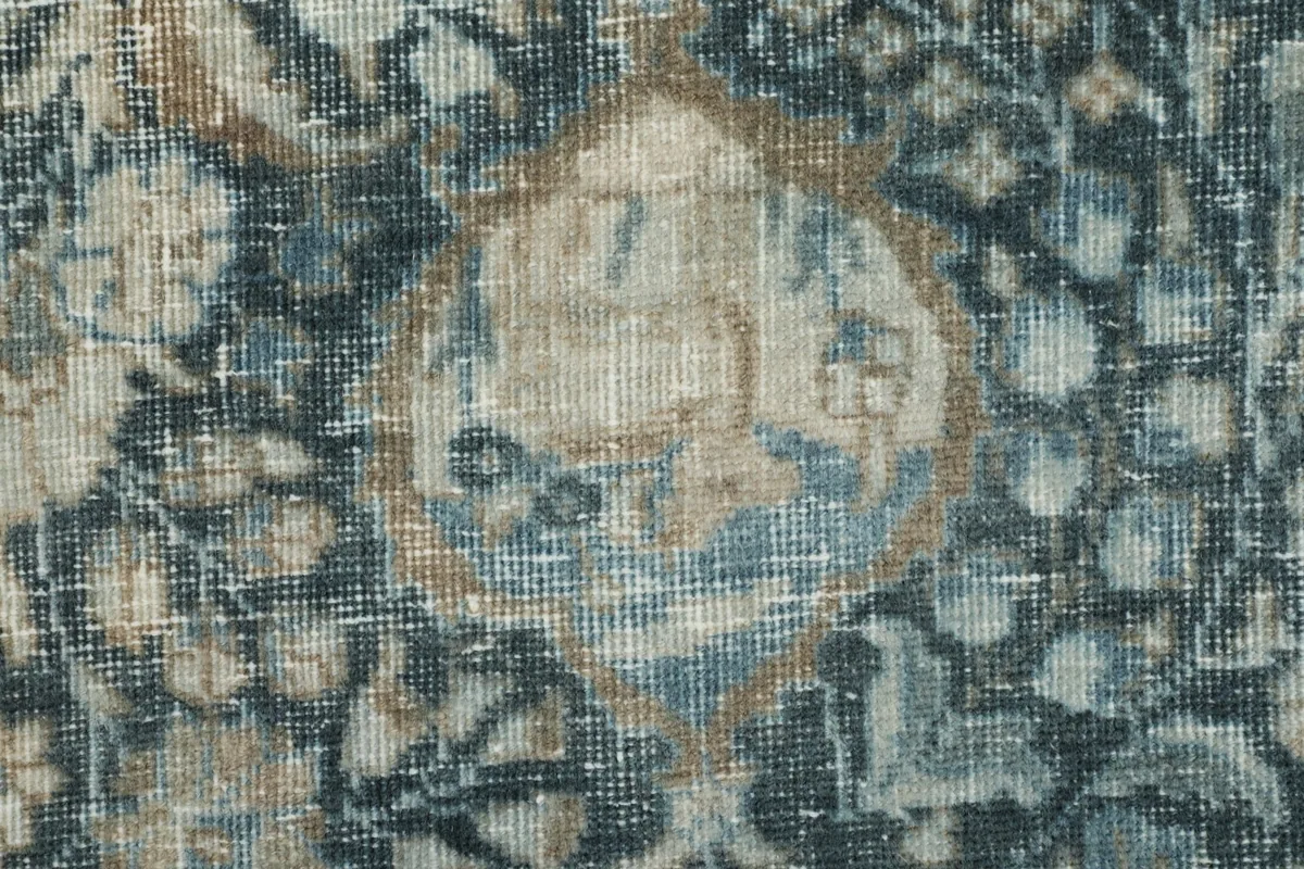 Detailed close-up of the wool pile and faded blue and tan colors in the rug's design