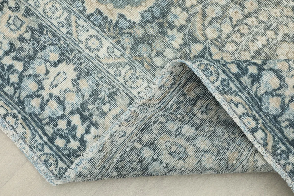 View of the rug folded back, revealing the wool pile and cotton foundation construction