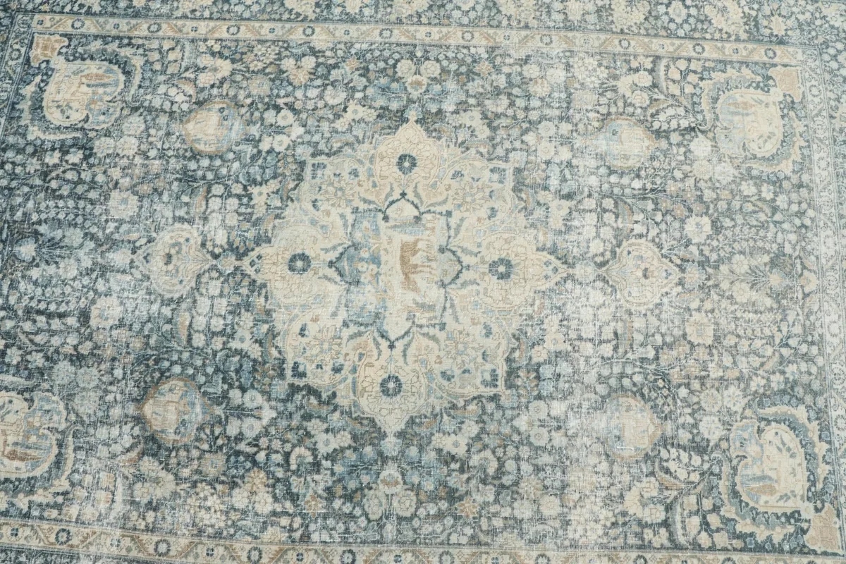 Overhead detail of the central medallion and surrounding floral patterns on the blue rug