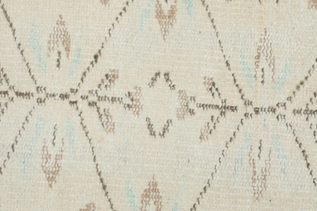Tight detail of the hand-knotted wool pile and cotton foundation, showing tan and blue threads.