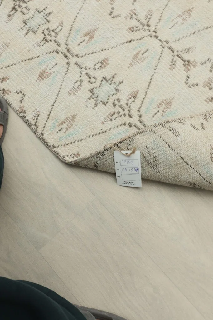 A close-up of the rug's label attached to the back, indicating its origin and material details.
