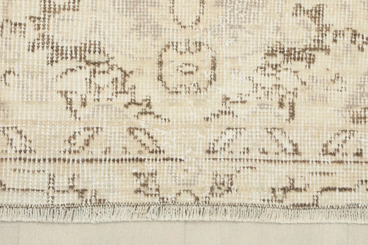 Close-up of the rug's border and fringe, showcasing the hand-knotted wool texture