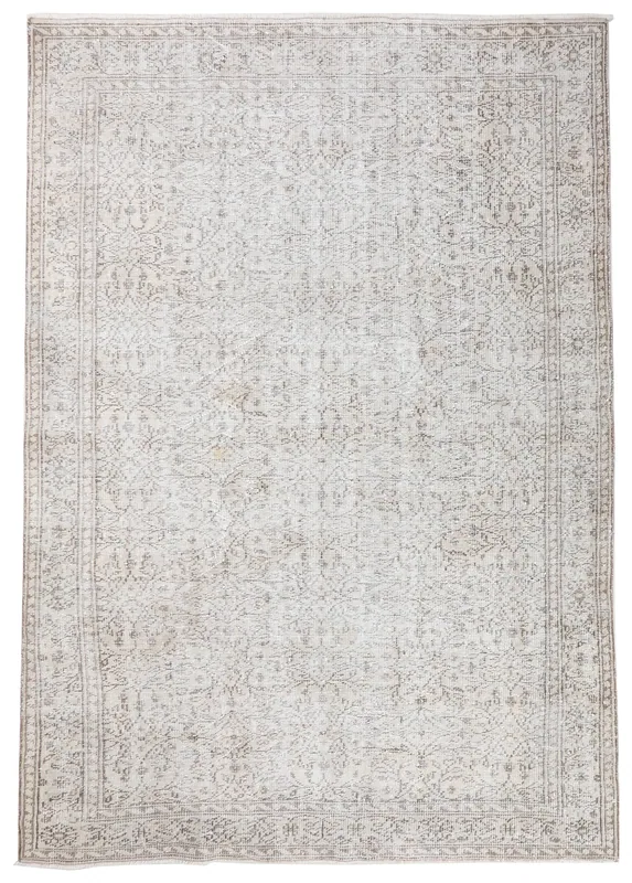 Full overhead view of the ivory and beige vintage Anatolian rug with floral patterns on a white background