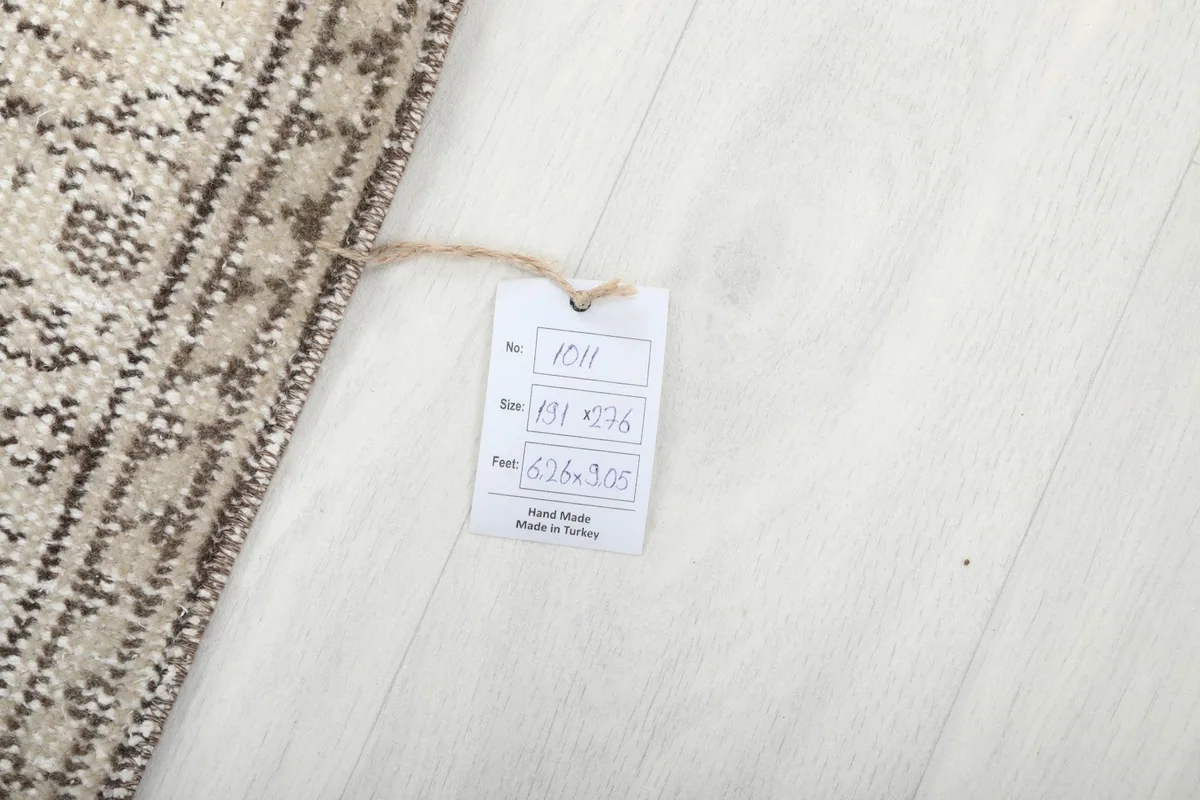 Tag showing the rug's dimensions in centimeters and feet, confirming its hand-made origin in Turkey