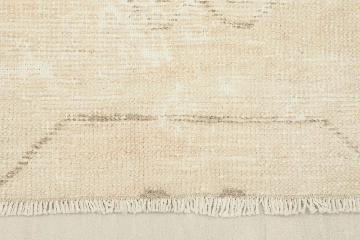 Close-up of the natural ivory fringe and the lower border design of the rug