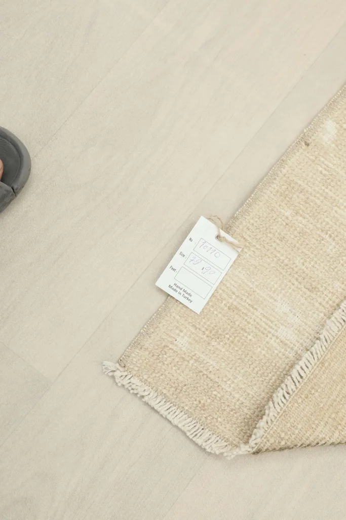 Rug's edge with product tag, showing the quality and origin details