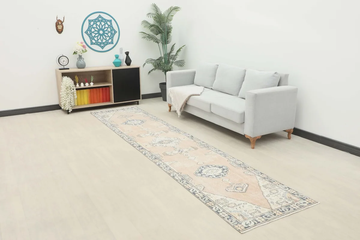 Rose tribal runner rug extending in a living room setup with a light gray sofa and modern decor.