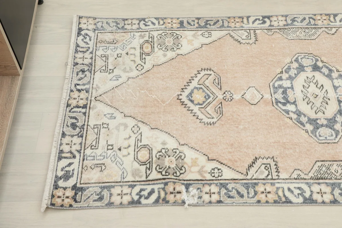 Detailed view of the runner's patterns and colors, showing the interplay of rose, navy, and ivory.