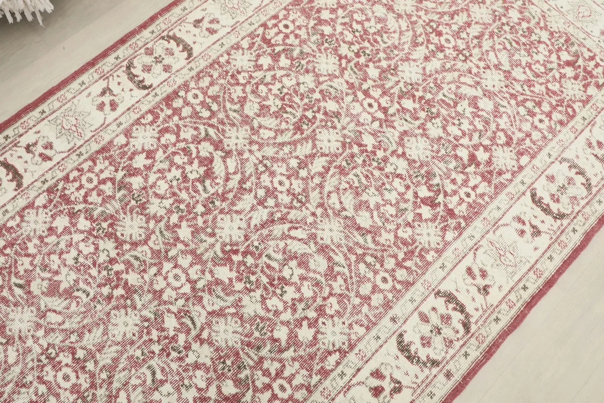 Overhead view focusing on the central floral design and the distressed texture of the rug