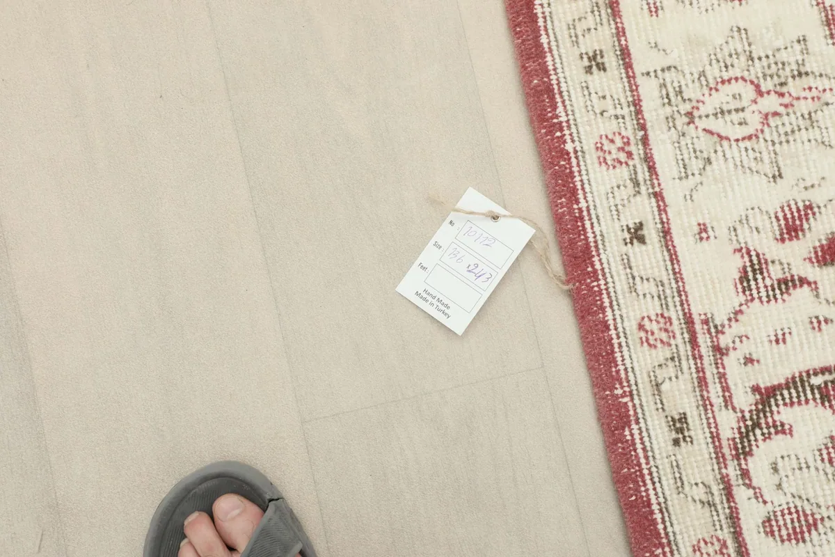 Small tag on the floor next to the rug's edge, showing the product label details