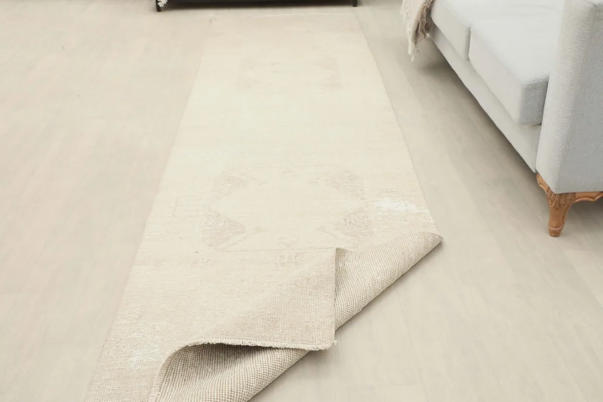 Runner rug with one end folded back, revealing the pile and foundation structure