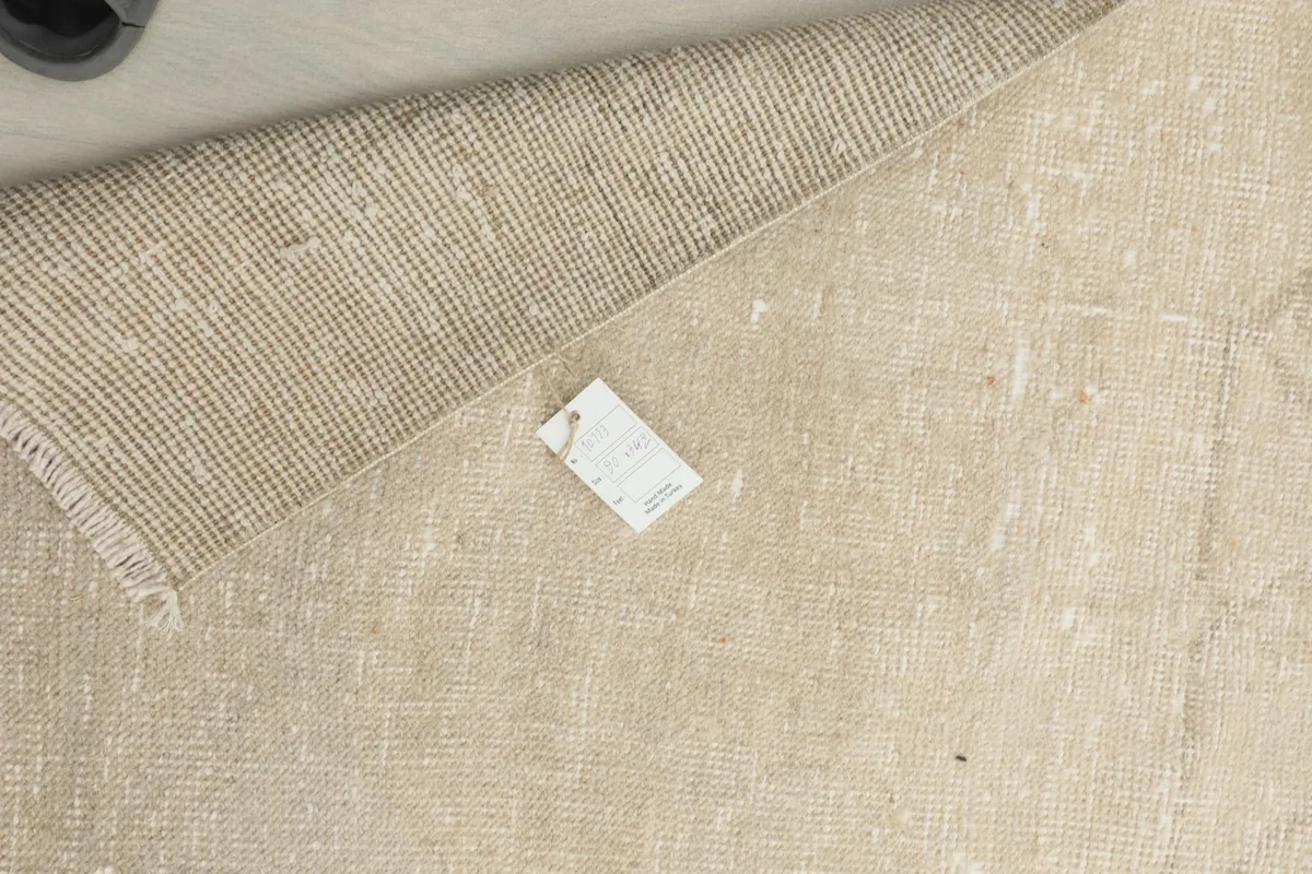 Close-up of the back of the rug with a label, showing the tight hand-knotted weave