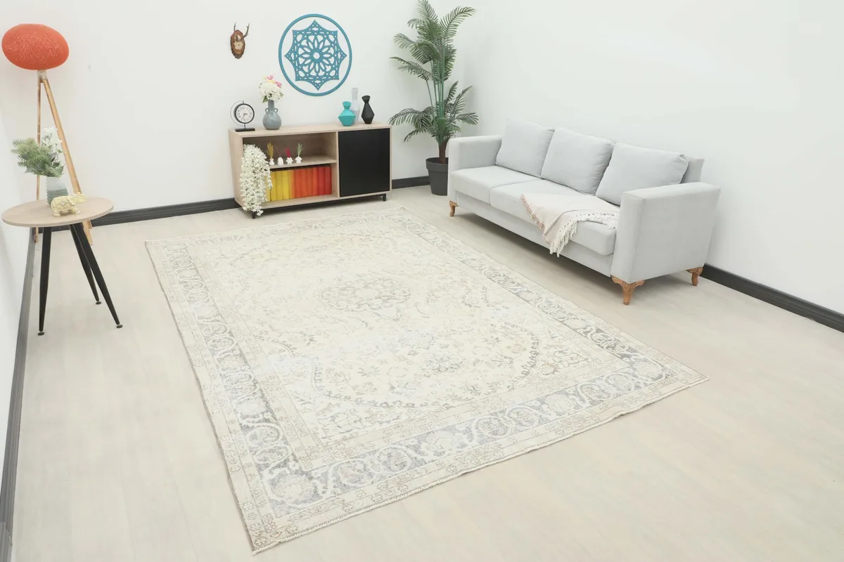 Ivory and gray vintage Anatolian rug displayed in a modern living room setting with a sofa