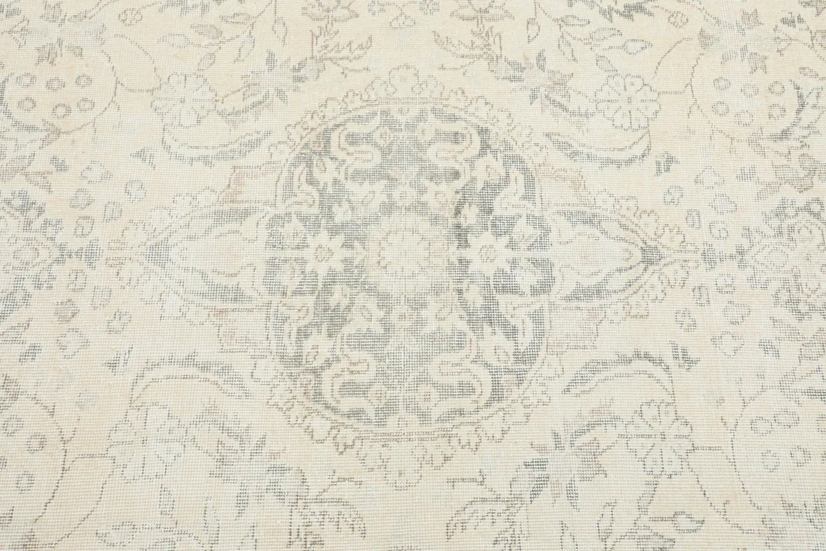 Detailed view of the central medallion and surrounding floral patterns in gray and ivory