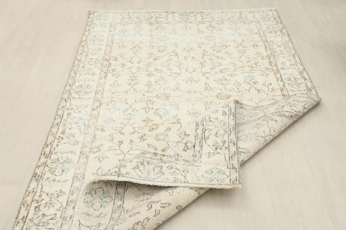 Rug partially folded, demonstrating its flexibility and vintage condition