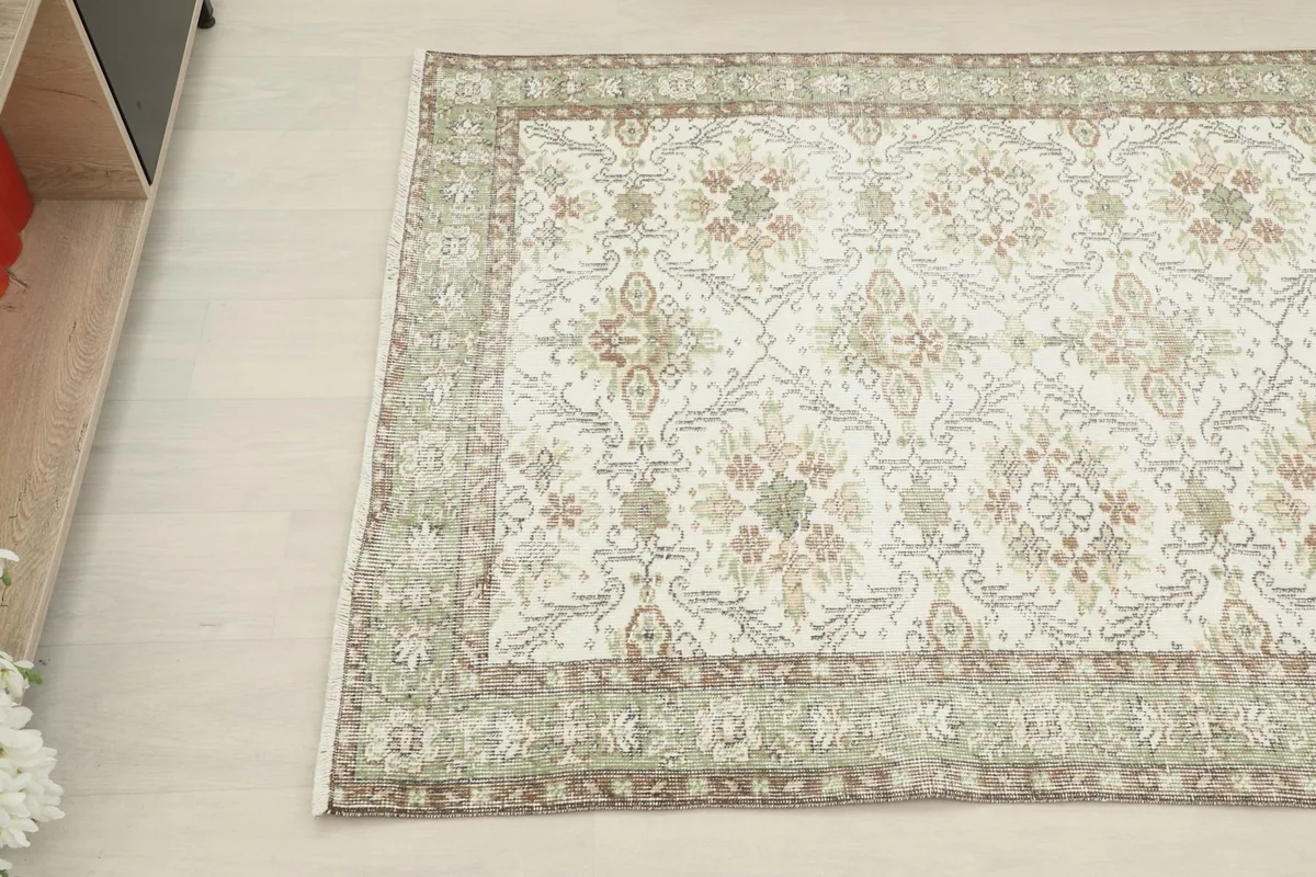 Overhead detail shot of the rug's pattern and border next to furniture