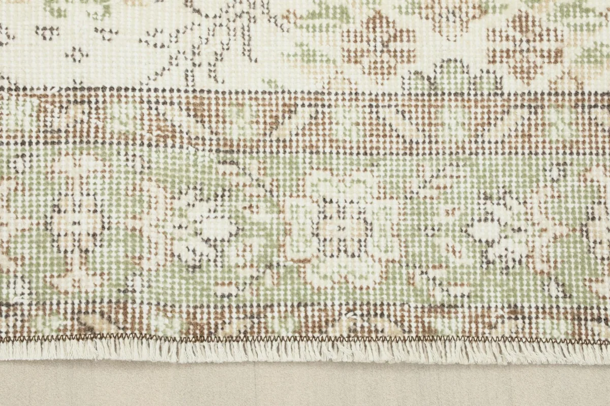 Close-up of the rug's edge, showing the border design and short fringes