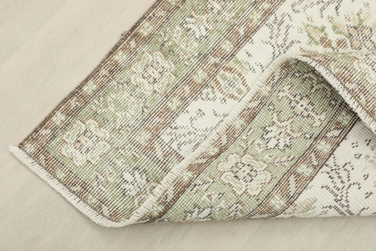View of the rug folded back slightly, revealing the underside and knotting