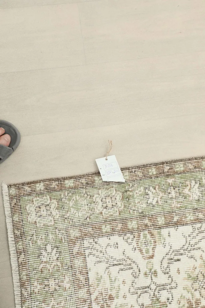 Tag attached to the rug's corner, with a foot for scale