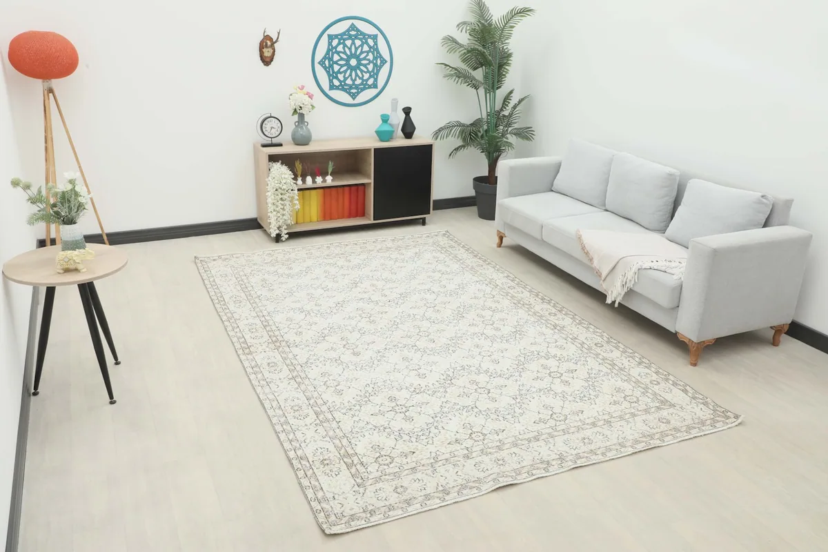 Vintage cream and gray rug displayed in a bright living room setting with a light sofa.