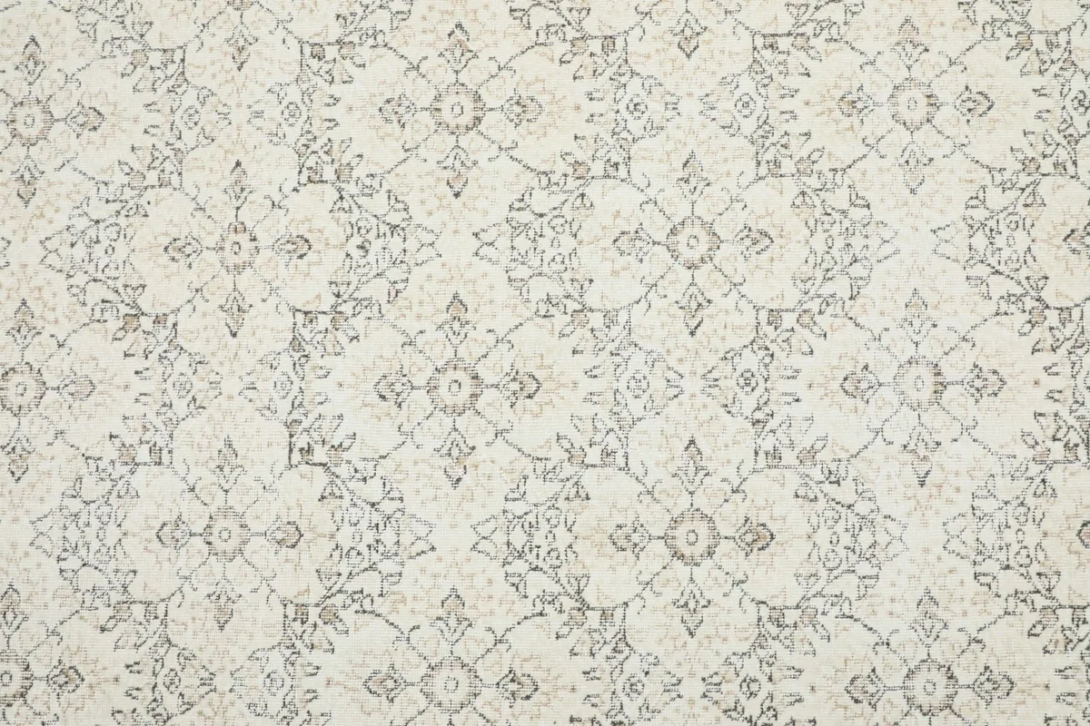 Close-up of the rug's central field, showing the intricate gray geometric and floral patterns.