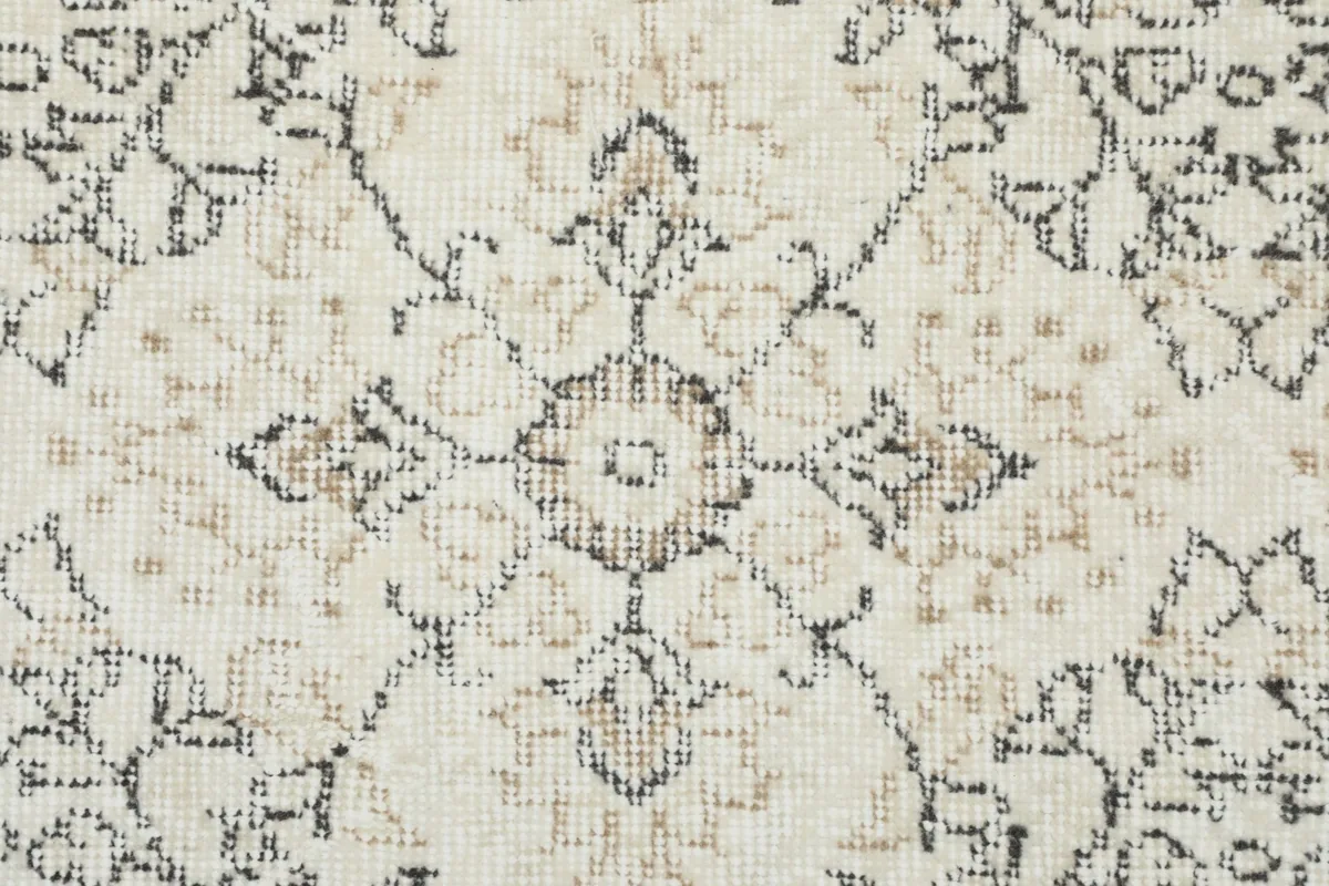 Detailed view of the wool pile, revealing the beige and black accents within the gray pattern.