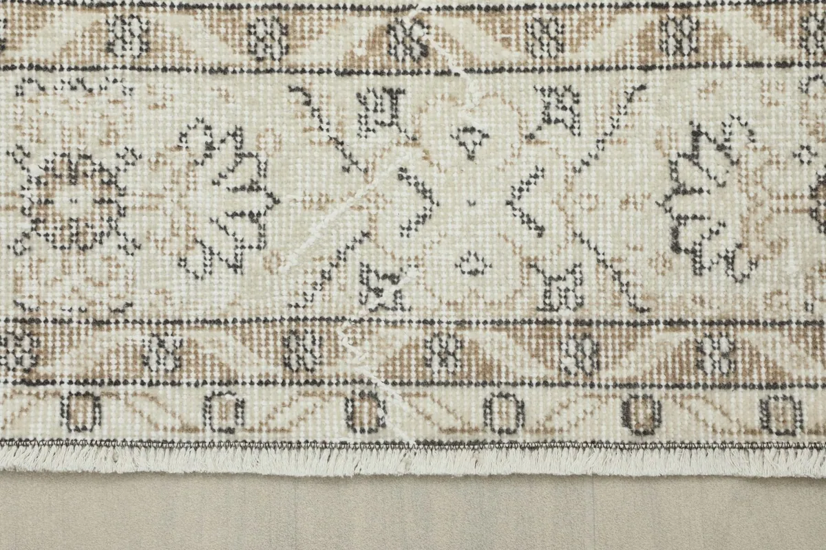 Close-up of the rug's border and a glimpse of the short, natural fringe.