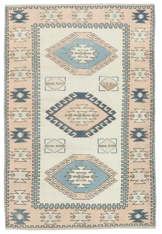 Full top view of the ivory, blue, and pink vintage Anatolian tribal rug on a white background.