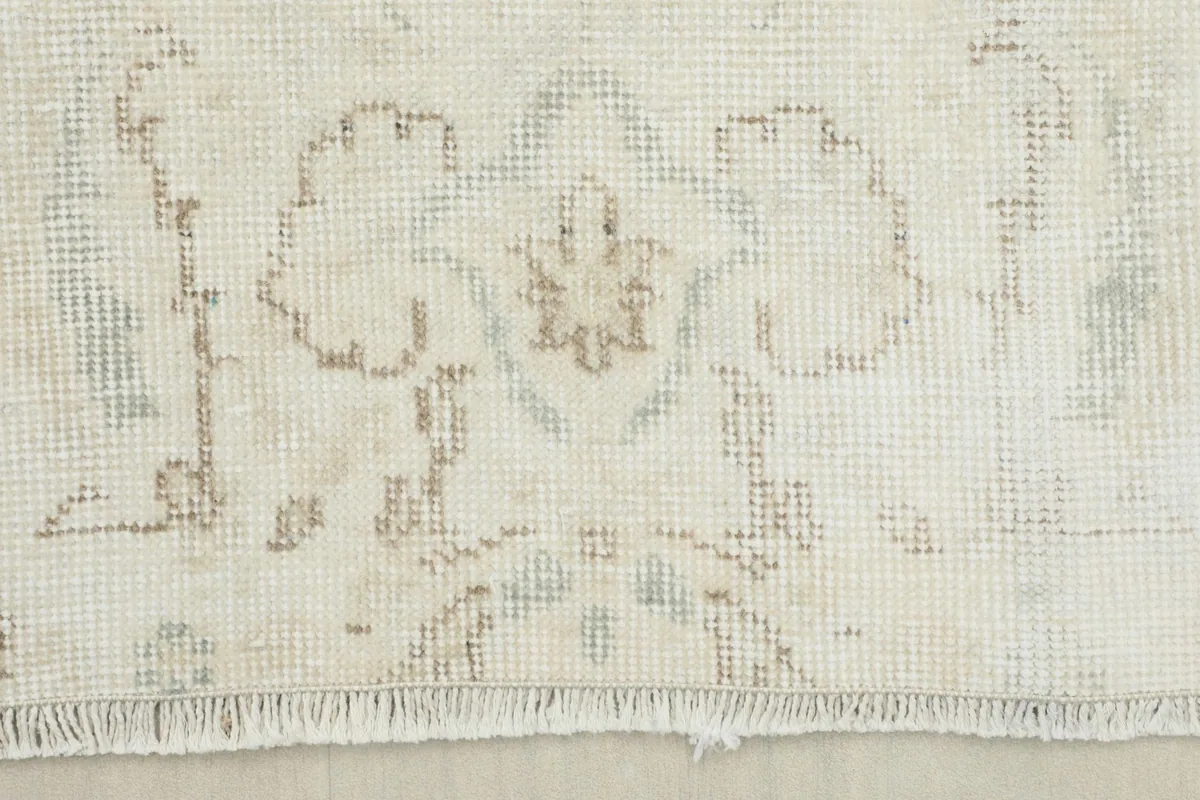 Close-up of the rug's border and a small section of the fringe, showing weave and wear.