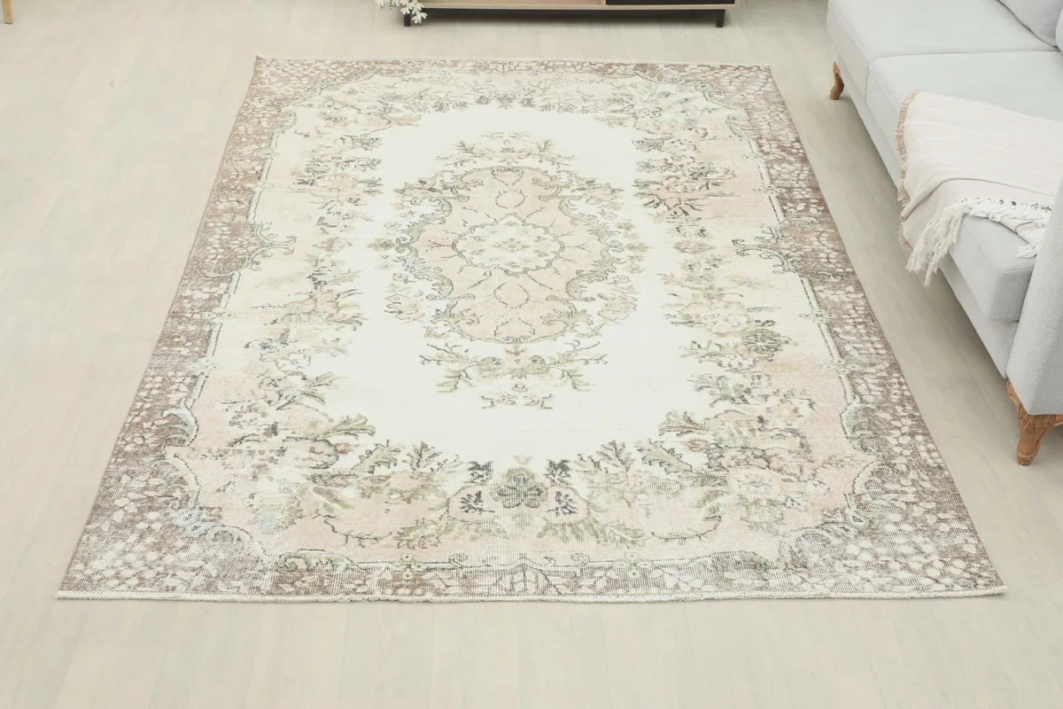 Full overhead view of the ivory beige floral medallion rug in a spacious room environment.