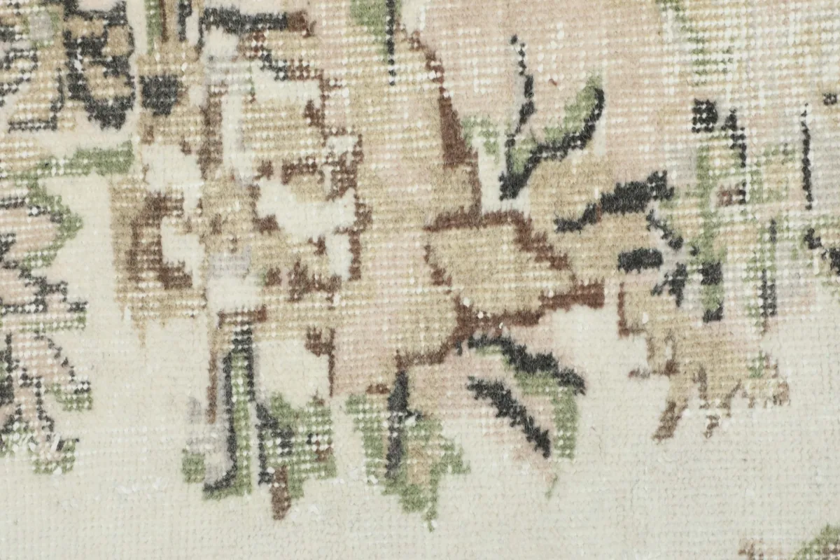 Close-up of the wool pile, showing the texture and muted colors of the floral design.