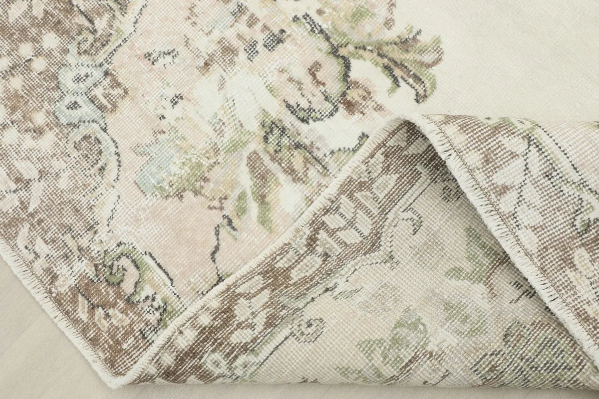 View of the rug folded back, revealing the hand-knotted cotton foundation and wool pile.