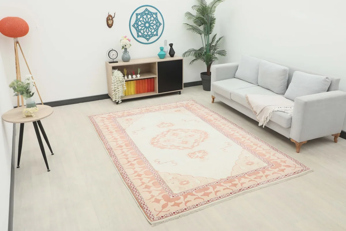 Medium ivory and rose vintage rug in a modern living room setting