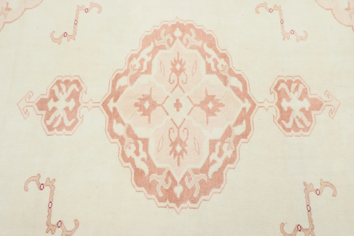 Close-up of the central rose medallion motif on the ivory vintage rug