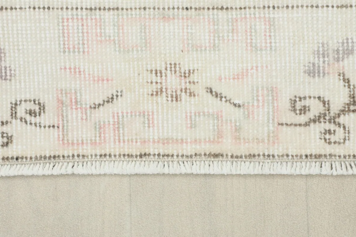 Detail of the short, natural cotton fringe and the tightly woven edge of the vintage rug.