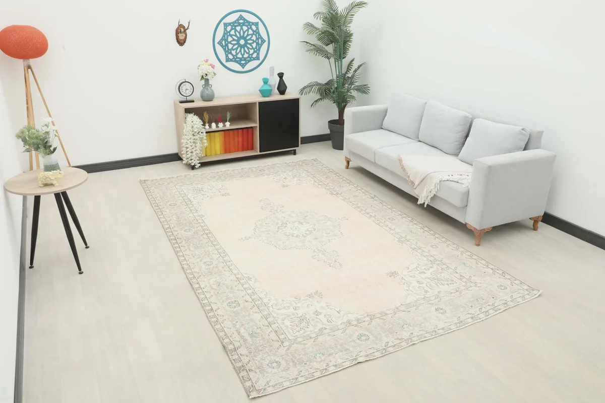 Large rose and gray vintage rug in a modern living room setting with a sofa