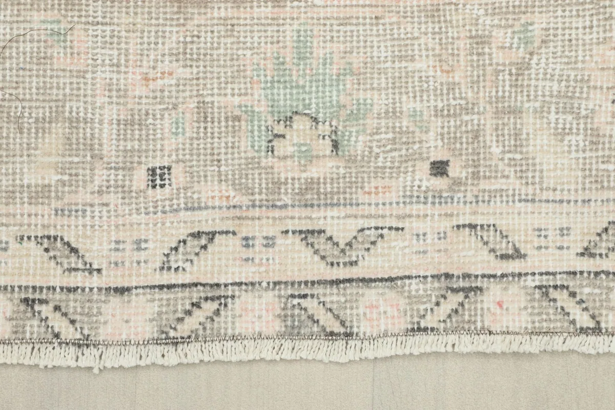 Close-up of the rug's edge, showing the short fringe and the back of the weave