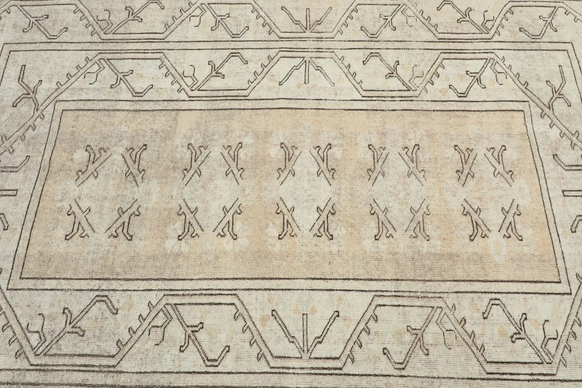 Detailed view of the central beige field with repeated charcoal tribal symbols