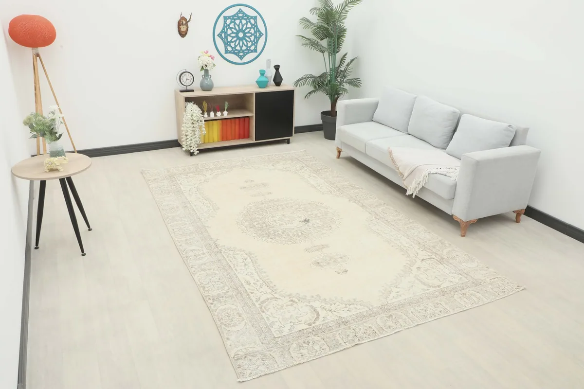 Ivory and gray vintage rug shown in a modern living room setting with a light sofa