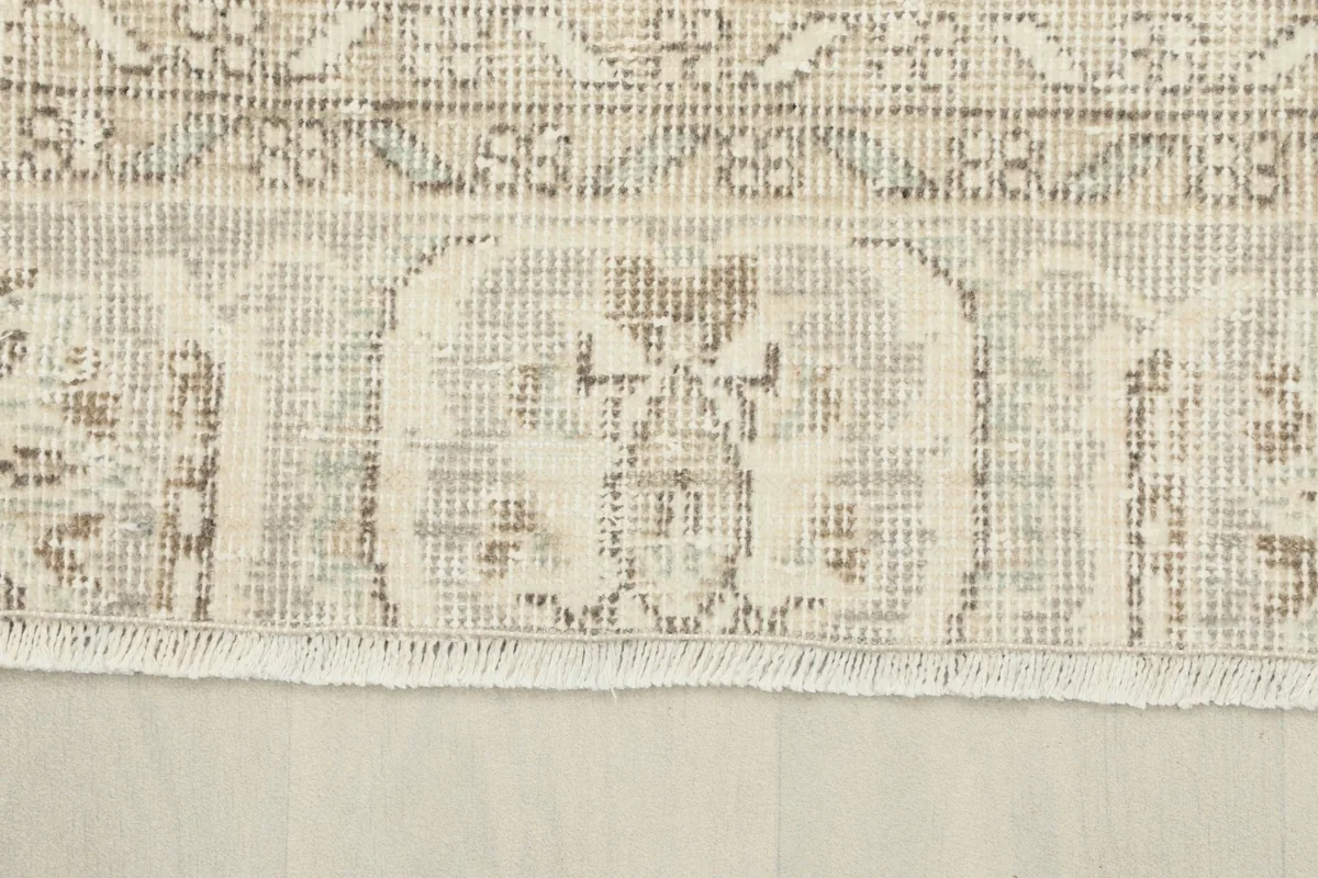 Close-up of the short, natural cotton fringe and the edge of the hand-knotted wool pile