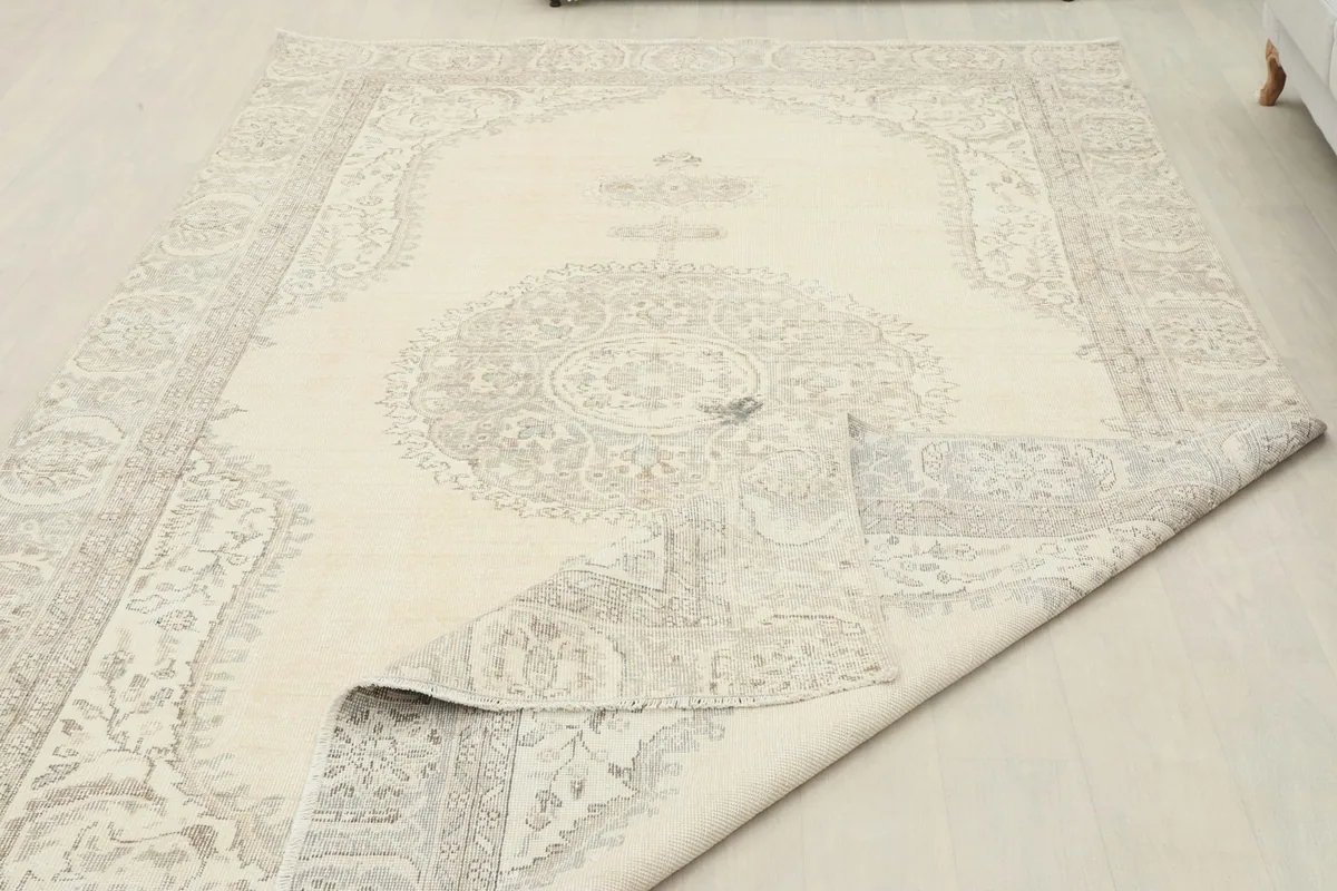 Rug partially folded, demonstrating its flexibility and the wool pile on cotton foundation