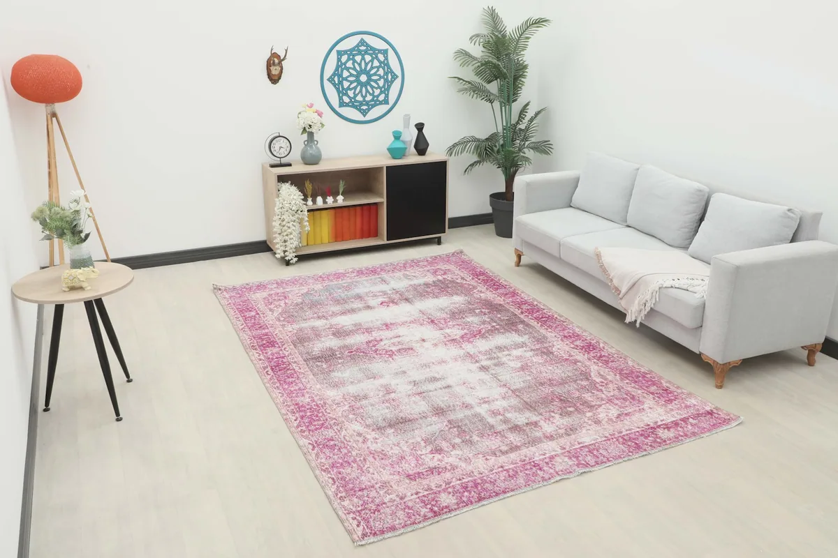 6'4" x 9'3" vintage rug in a living room setting with a light gray sofa and side table