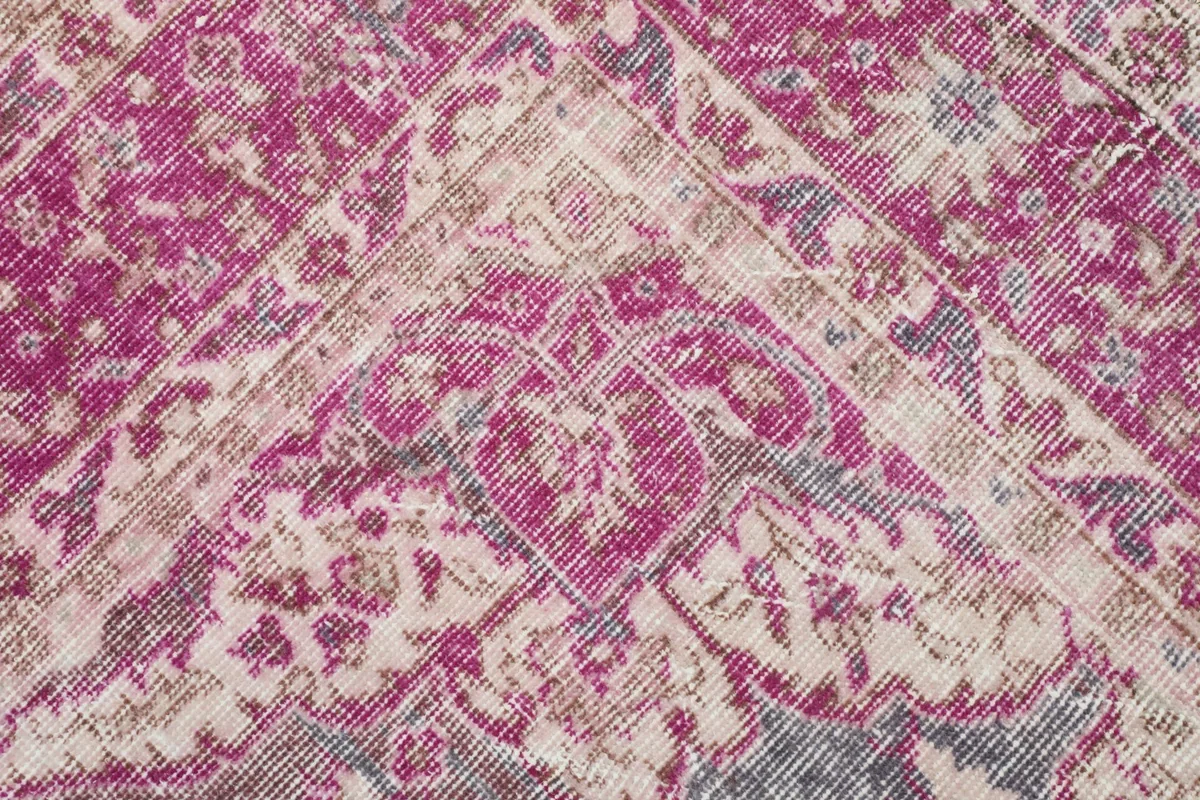 Close-up of the intricate floral and geometric patterns within the pink border and gray field