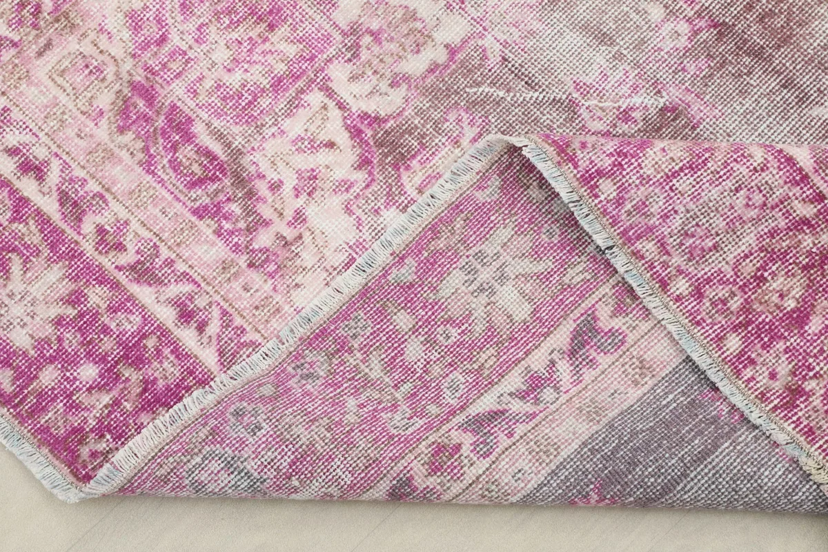 Folded corner of the rug revealing the cotton foundation and hand-knotted construction