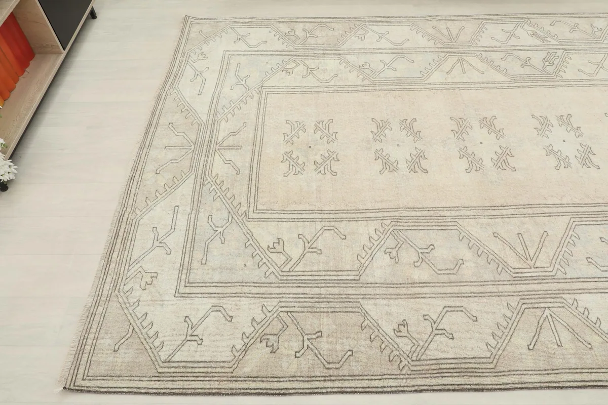 Another angled perspective of the rug, showing its full width and the intricate gray patterns on the beige background.