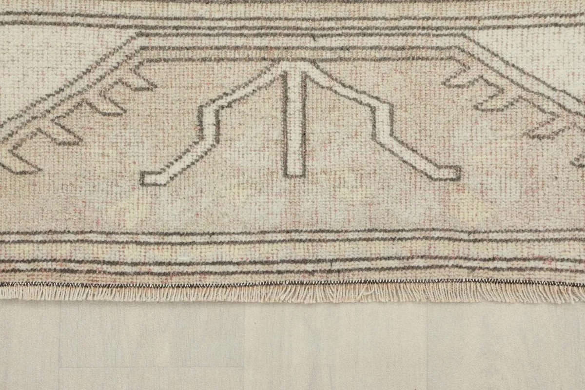 Close-up of the rug's short end, showing the outer border design and the subtle fringe.
